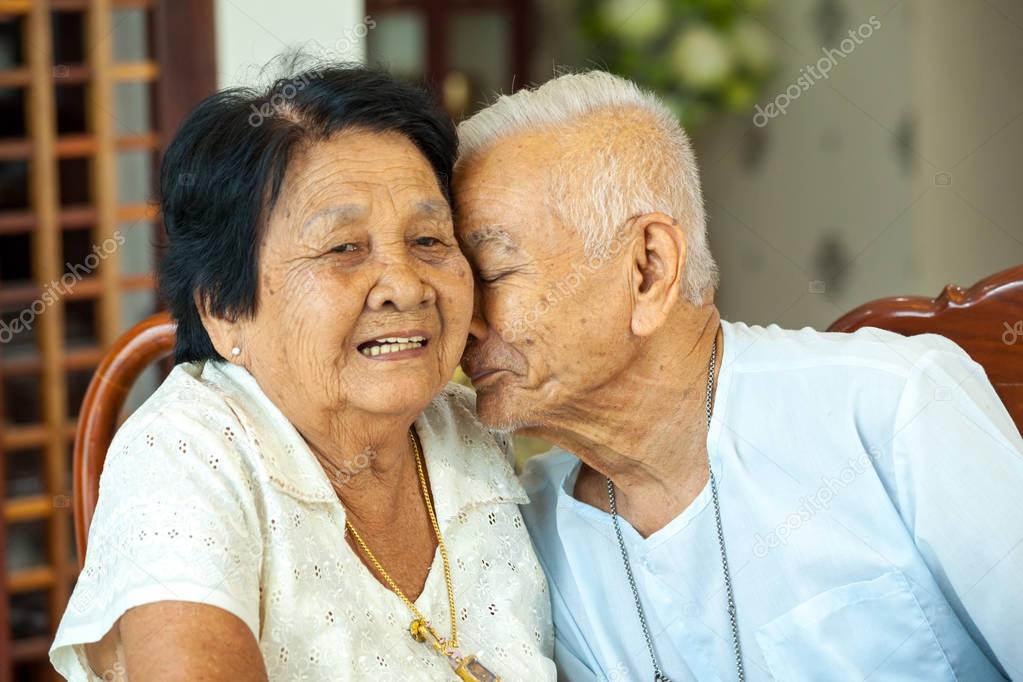 Asian Senior man kissing senior woman
