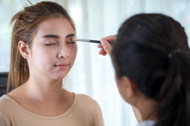 Asyalı kadın onun uzun kirpiklerini rimel uygulamak