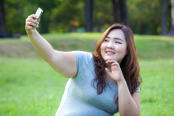 Fêmea gorda tira selfie de viagem no parque — Fotografia de Stock