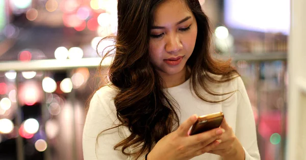Ung asiatisk kvinna använder sin mobiltelefon — Stockfoto