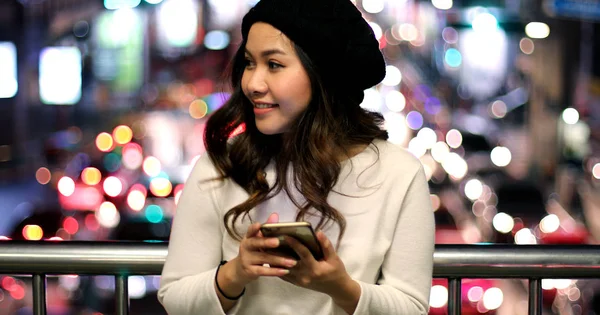 Joven mujer asiática usando su teléfono móvil — Foto de Stock