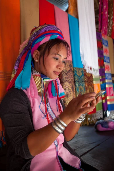 Mujer vistiendo el tradicional con el teléfono móvil en un tejido en Fotos de stock