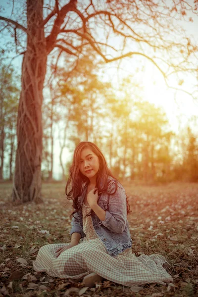 Young asian woman in an autumn park — Stockfoto