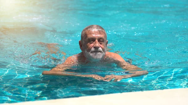 老人は屋外プールで泳いでいます — ストック写真