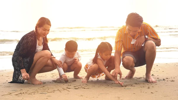 Młoda Czteroosobowa Rodzina Siedzi Gra Piasku Plaży — Zdjęcie stockowe