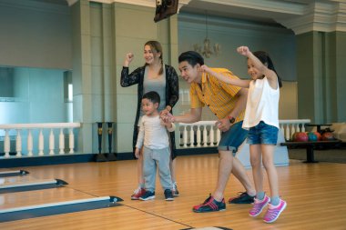 Genç aile bowling kulübünde eğleniyor.