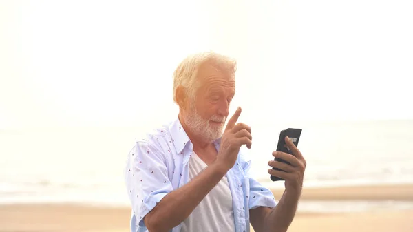 해변에서 노인에게 메시지를 보내는 — 스톡 사진
