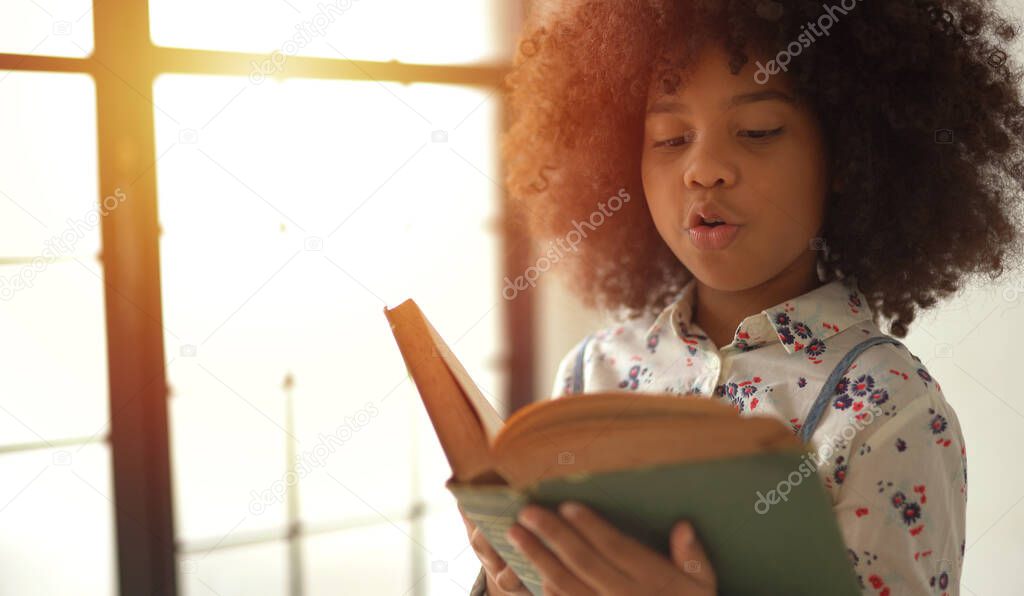 African Girl reading text book in home