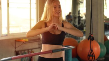 Güzel beyaz kadın spor salonunda hula hoop yapıyor.