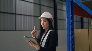 Depo çalışanı büyük bir depoda tablet kullanıyor.