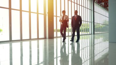 Pilot ve patron havaalanı terminalinde konuşuyor.