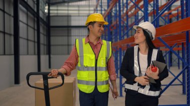 Dağıtım deposunda çalışırken sevkiyatı kontrol eden depo çalışanları.