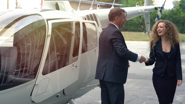 ビジネスの男と女のグループは 空港での旅行から戻った後 ヘリコプターを降りた ストックフォト