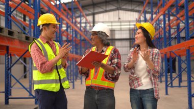 Dağıtım deposunda çalışırken sevkiyatı kontrol eden depo çalışanları.