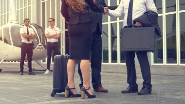 Bir grup iş adamı ve kadın havaalanından döndükten sonra helikopterden indiler.