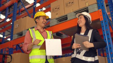 Dağıtım deposunda çalışırken sevkiyatı kontrol eden depo çalışanları.