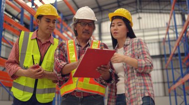 Dağıtım deposunda çalışırken sevkiyatı kontrol eden depo çalışanları.