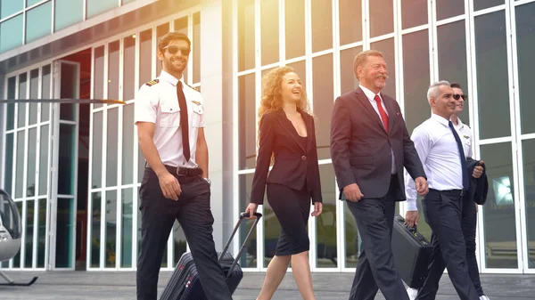 Group of business man and woman walked off a helicopter after returning from traveling at airport