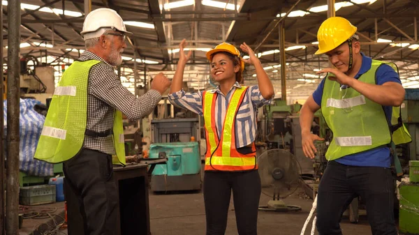 Happy Team Of Engineers dancing In Factory