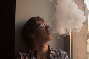 Pencere yakınındaki Elektronik Sigara İçilmeyen genç adam.