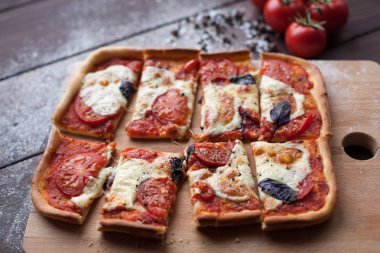 Mozzarella, peynir ve fesleğen yapraklı kırsal İtalyan pizzası.