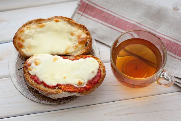 Peynir ve ahşap masa üzerinde çay ile açık sandviç. Kahvaltı konsepti — Stok fotoğraf