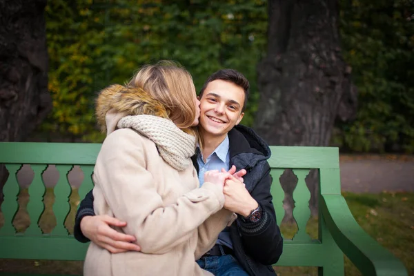 Genç çocuk ve bankta oturan sarılma ve öpüşme, kız — Stok fotoğraf