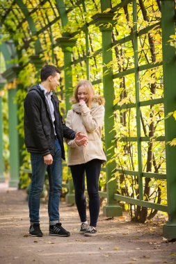 Genç kız ve bir adam parkta, sarılma ve öpüşme yürüyor. romantik ruh hali