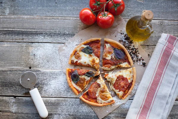 Appetizing pizza margarita on a wooden table in daylight. Vegetarian dish. Top view