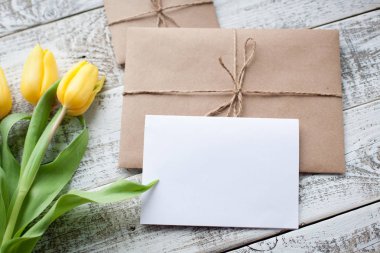 Sarı Lale buketi ve boş tebrik kartı. Ahşap masa üzerinde Üstten Görünüm