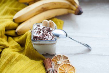 Kremalı puding muz, çikolata, ve mermer bir zemin üzerine tarçın.