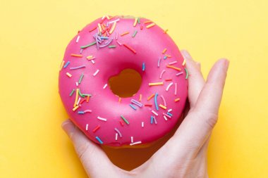 Kadın eli sır parlak turuncu zemin üzerine çilek çörek alır