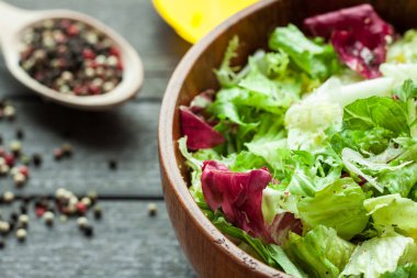 Bir tabak taze salata frisse, Romano ve zeytin yağı, tuz ve taze zemin percec ahşap bir kase ile radiccio