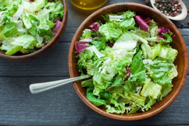 Bir tabak taze salata frisse, Romano ve zeytin yağı, tuz ve taze zemin percec ahşap bir kase ile radiccio