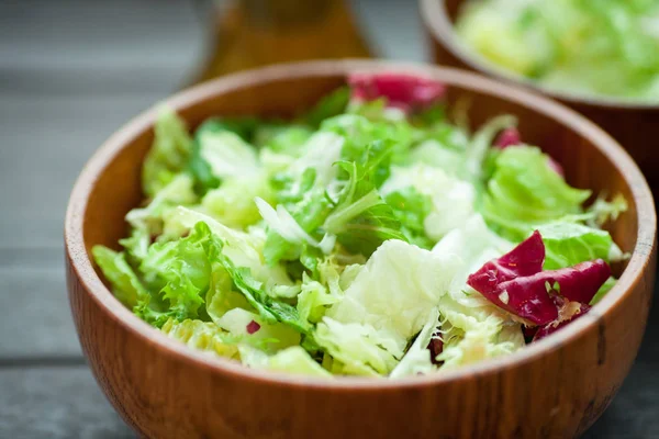 Een schotel van verse salade-frisse, Romano en radiccio met olijfolie, zout en vers grond percec in een houten kom — Stockfoto