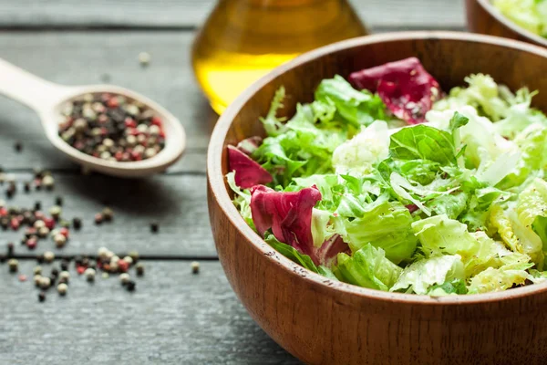 Een schotel van verse salade-frisse, Romano en radiccio met olijfolie, zout en vers grond percec in een houten kom — Stockfoto