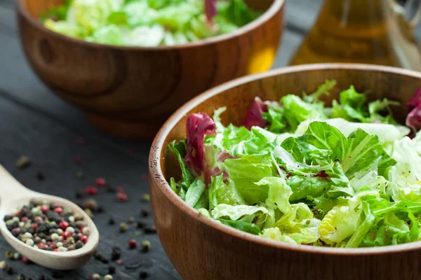 Een schotel van verse salade-frisse, Romano en radiccio met olijfolie, zout en vers grond percec in een houten kom — Stockfoto