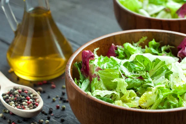 Een schotel van verse salade-frisse, Romano en radiccio met olijfolie, zout en vers grond percec in een houten kom — Stockfoto