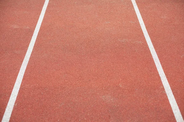 white bent lines marking red stadium with soft covering