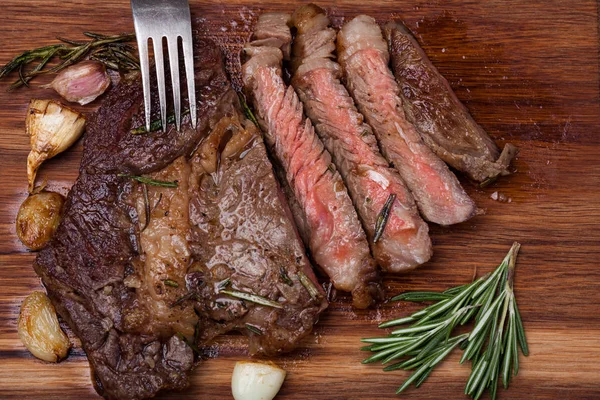 烤肋眼牛排的大理石牛肉特写与香料在木板上。多汁的牛排介质罕见、 切片、 准备吃 — 图库照片