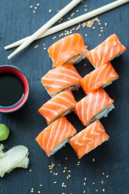 Philadelphia rulo klasik karanlık bir taş zemin üzerine. Philadelphia peyniri, salatalık, avokado. Japon suşi. Üstten Görünüm