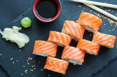 Philadelphia rulo klasik karanlık bir taş zemin üzerine. Philadelphia peyniri, salatalık, avokado. Japon suşi. Üstten Görünüm