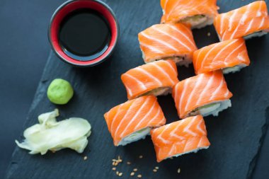 Philadelphia rulo klasik karanlık bir taş zemin üzerine. Philadelphia peyniri, salatalık, avokado. Japon suşi. Üstten Görünüm