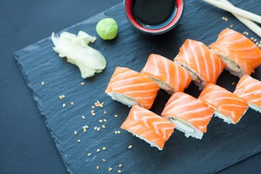 Philadelphia rulo klasik karanlık bir taş zemin üzerine. Philadelphia peyniri, salatalık, avokado. Japon suşi. Üstten Görünüm