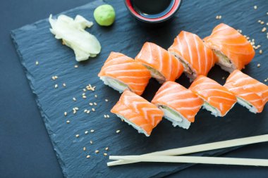 Philadelphia rulo klasik karanlık bir taş zemin üzerine. Philadelphia peyniri, salatalık, avokado. Japon suşi. Üstten Görünüm