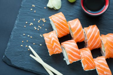 Philadelphia rulo klasik karanlık bir taş zemin üzerine. Philadelphia peyniri, salatalık, avokado. Japon suşi. Üstten Görünüm