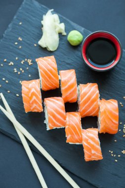 Philadelphia rulo klasik karanlık bir taş zemin üzerine. Philadelphia peyniri, salatalık, avokado. Japon suşi. Üstten Görünüm