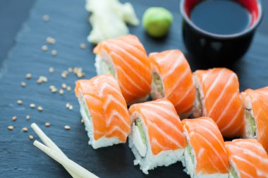 Philadelphia rulo klasik karanlık bir taş zemin üzerine. Somon, Philadelphia peyniri, salatalık, avokado. Japon suşi.