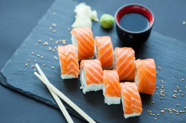 Philadelphia rulo klasik karanlık bir taş zemin üzerine. Somon, Philadelphia peyniri, salatalık, avokado. Japon suşi.