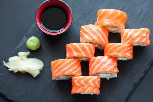 Philadelphia roll klassieker op een donkere achtergrond van de stenen. Philadelphia kaas, komkommer, avocado. Japanse sushi. Bovenaanzicht — Stockfoto